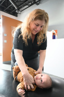 Dr. Altman adjusting an infant. 1