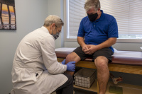 Dr. Grimsley examines a patient's knee.  0